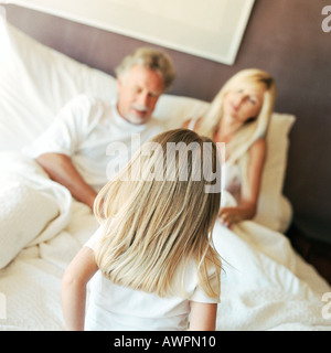 Mädchen im Gespräch mit den Eltern im Bett, Rückansicht Stockfoto