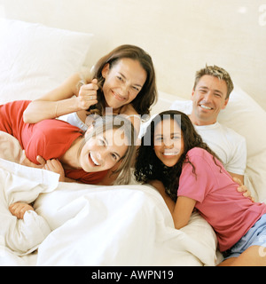 Familie auf Bett, Lächeln Stockfoto