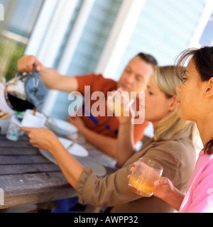 Mädchen, das Frühstück mit den Eltern außerhalb Stockfoto