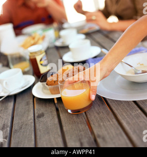 Hand setzen Glas Saft auf Tisch, Nahaufnahme Stockfoto