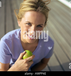 Frau mit Apfel, erhöhte Ansicht, Porträt Stockfoto