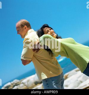 Paar stehen Rücken an Rücken, draußen, Lächeln Stockfoto