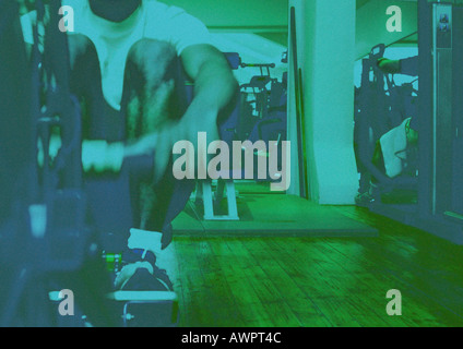 Mann mit Rudergerät im Fitness-Studio Stockfoto