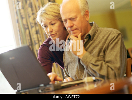 Älteres Paar, Mann mit Laptop, Frau über die Schulter schauen Stockfoto