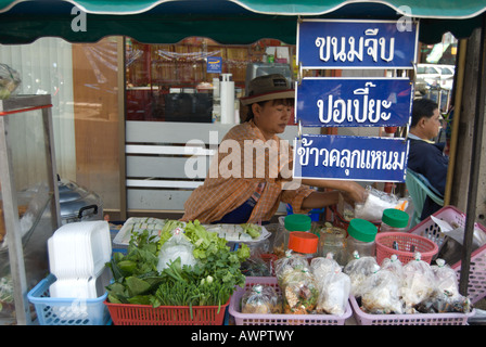 von ihrem Straßenstand bietet dieser weiblichen thai-Food-Anbieter Frühlingsrollen, Dim Sum und andere Gerichte Stockfoto