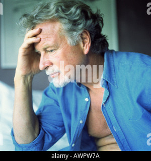 Profil von Man mit nachdenklichen Ausdruck und Hand auf Stirn Stockfoto