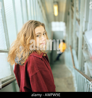 Frau auf der Suche über die Schulter im stehen am Anfang der Treppe, Porträt Stockfoto