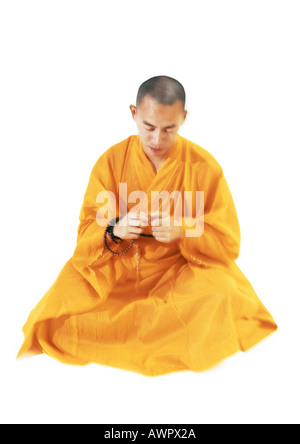 Buddhistischer Mönch sitzen und meditieren, hält Gebetskette Stockfoto