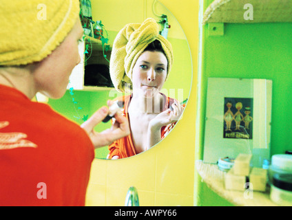 Junge Frau setzen auf Make-up, Fokus auf Reflexion im Spiegel. Stockfoto