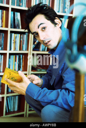 Junger Mann vor cd-Sammlung, Blick in die Kamera, Porträt. Stockfoto