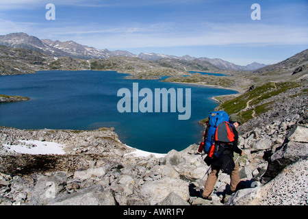 Wanderer, Schnee, Berglandschaft und Kratersee, Chilkoot Trail, British Columbia, Kanada Stockfoto