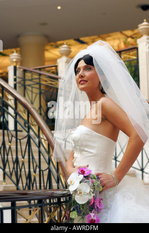 Schöne lächelnde Braut im weißen Kleid mit Schleier am Hochzeitstag Stockfoto
