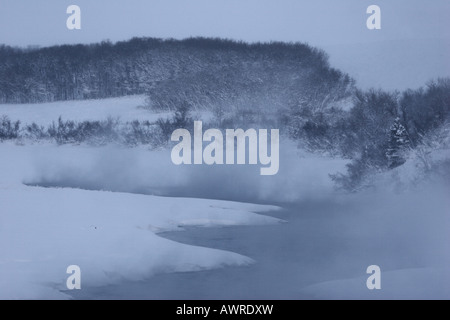 Nebel steigt aus offenen Gewässern im winter Stockfoto