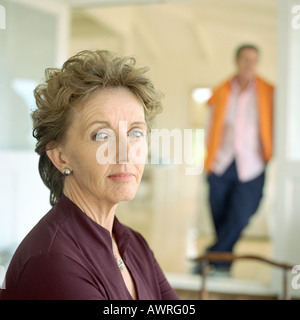 Reife Frau, Blick in die Kamera, Mann im Hintergrund, Porträt Stockfoto