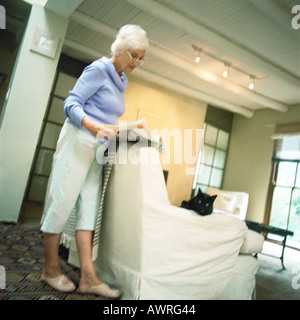 Reife Frau im Wohnzimmer, lesen Stockfoto