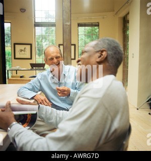 Zwei reife Männer am Tisch sitzen, lachen Stockfoto