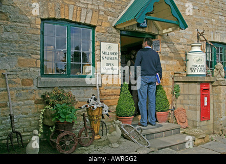 Mann in The Old Mill-Shop und Museum, Lower Slaughter, Cotswolds, UK Stockfoto