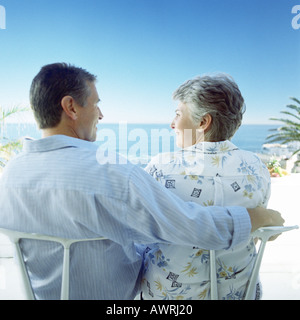 Älteres Paar am Strand, Mannes Arm um Frau, Rückansicht Stockfoto