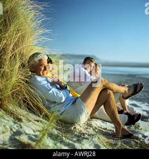 Ältere Gruppe sitzt am Strand Stockfoto