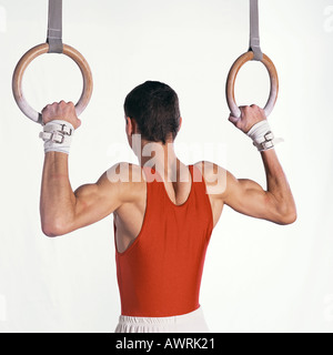 Männlichen Turner selbst hochziehen an den Ringen, Rückansicht Stockfoto