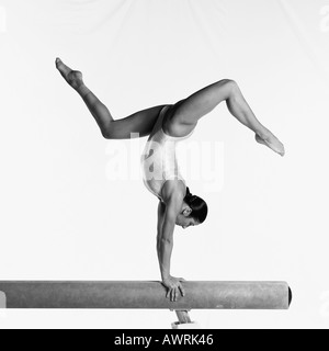 Junge weibliche Turnerin am Schwebebalken, die Durchführung von Routine, seitliche Ansicht Stockfoto