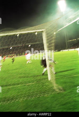 Fußball-Spieler während eines Spiels, hinter das Ziel, verschwommen gesehen. Stockfoto