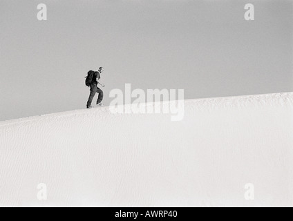 Wandern entlang dem Kamm der Düne, Seitenansicht, b&w Mann Stockfoto