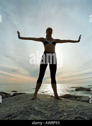 Frau am Strand, Arme ausgefahren, silhouette Stockfoto