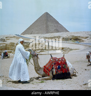 Arabische gekleidet in lange weiße Baumwolle fließen traditionelle Gewänder mit Kamel in Vorder- und hinter-Pyramide in Gizeh Ägypten im Jahre 1965 Stockfoto