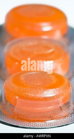 Ein Streifen von drei orange Hals Lutschtabletten Stockfoto