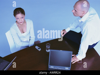 Geschäftsfrau im Stuhl, Mann sitzt am Schreibtisch, erhöht, Ansicht Stockfoto