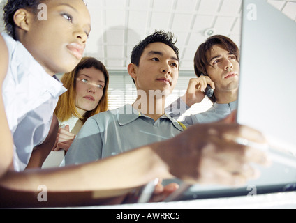Vier junge Menschen, eine Holding-Laptop, niedrigen Winkel Ansicht Stockfoto