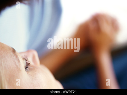 Frau Gesicht, Frau und Mann Hand in Hand, verschwommen im Hintergrund, erhöhte Ansicht Stockfoto