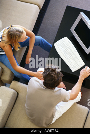 Mann und Frau sitzen im Wohnzimmer mit Computer, erhöhte Ansicht Stockfoto