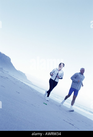 Reifer Mann und Frau läuft am Strand Stockfoto