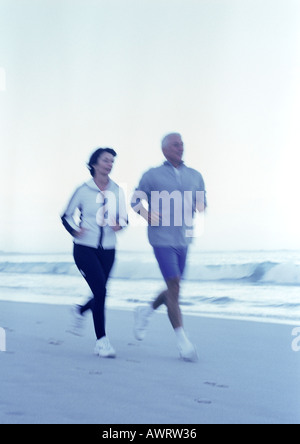 Reifer Mann und Frau läuft am Strand Stockfoto