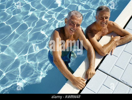 Zwei reife Männer, die auf Seite des Schwimmbad, Porträt, erhöhten Blick ruht Stockfoto