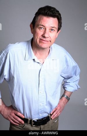 Gut aussehende Mann mittleren Alters lässig gekleidet mit Händen in den Hüften Stockfoto