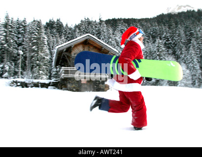 SANTA CLAUS MIT SNOWBOARD IM SCHNEE Stockfoto