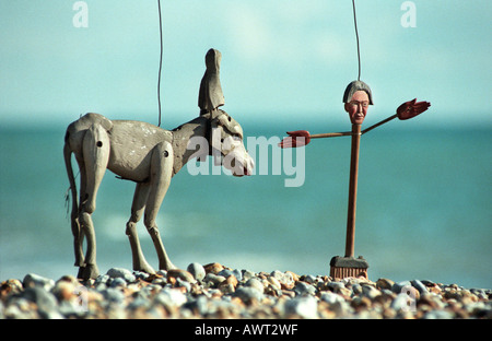 Kiesstrand an Meeresküste Mann und Marionette Pferd aufkleben Stockfoto