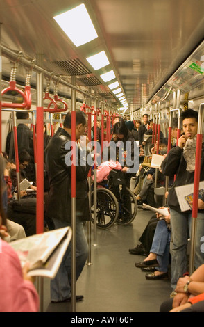 dh Mass Transit Railway MTR HONGKONG Passagiere stehen in Zug Frau und Rollstuhl china überfüllt pendeln U-Bahn-Pendler Stockfoto