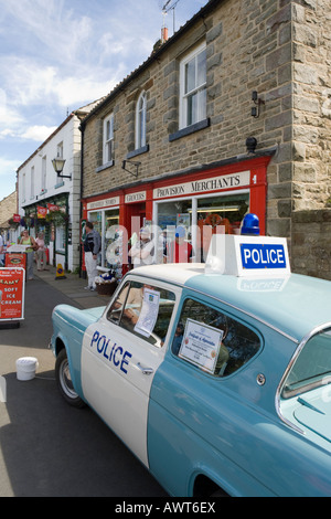 Panda Polizeiauto vor Aidensfield Geschäften im Dorf Goathland. North Yorkshire Stockfoto