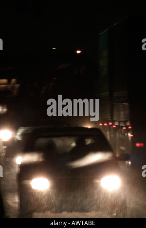 Autos auf einer Straße in der Nacht während eines Schneesturms Stockfoto