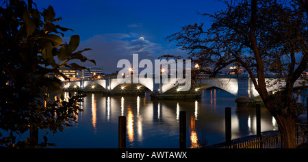 Umrahmt von Bäumen, die Abend-Reflexionen der Putney Bridge in London an der Themse, mit dem Mond-Overhead zu tanzen. Stockfoto