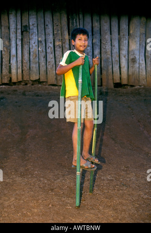 1 einen Schwarzen Lahu junge Wandern auf Bambus Stelzen, ethnische Gruppe, ethnische Minderheit, Hill Tribe, Dorf, Provinz Chiang Rai, Thailand, Asien Stockfoto