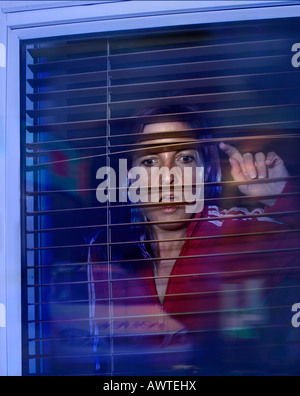 Frau aus dem Fenster betrachten Polizeiauto, Nacht Zeit drama Stockfoto