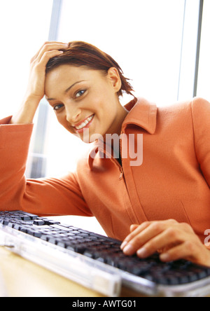 Frau am Keyboard, lächelnd in die Kamera Stockfoto