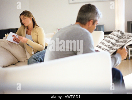 Mann und Frau sitzen auf der Couch lesen Stockfoto