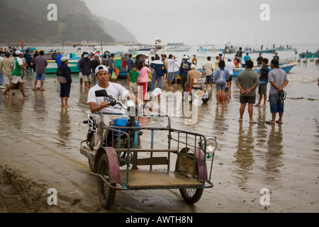 Mann auf Dreirad arbeiten für Fischindustrie auf nassen Strand Puerto Lopez Fischerei Hafen Ecuador Südamerika Stockfoto