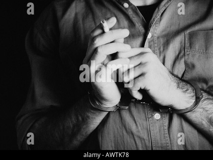 Mann mit Handschellen und Holding Zigarette, Nahaufnahme, b&w Stockfoto